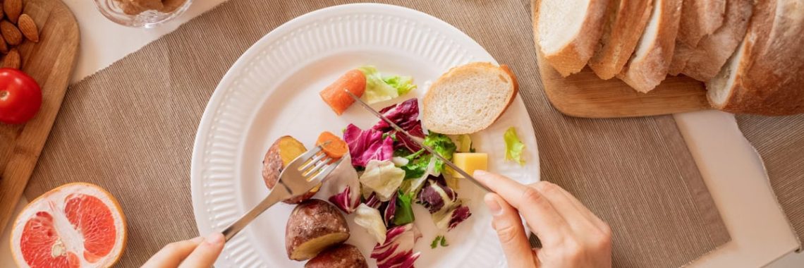 Top view of a nutritious breakfast setup with salad, bread, and fresh juice, perfect for a healthy start.